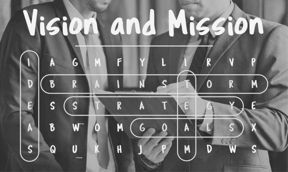 Two businessmen discussing while holding a clipboard, with a word search puzzle overlay featuring the words vision, mission, brainstorm, strategy, and goals.