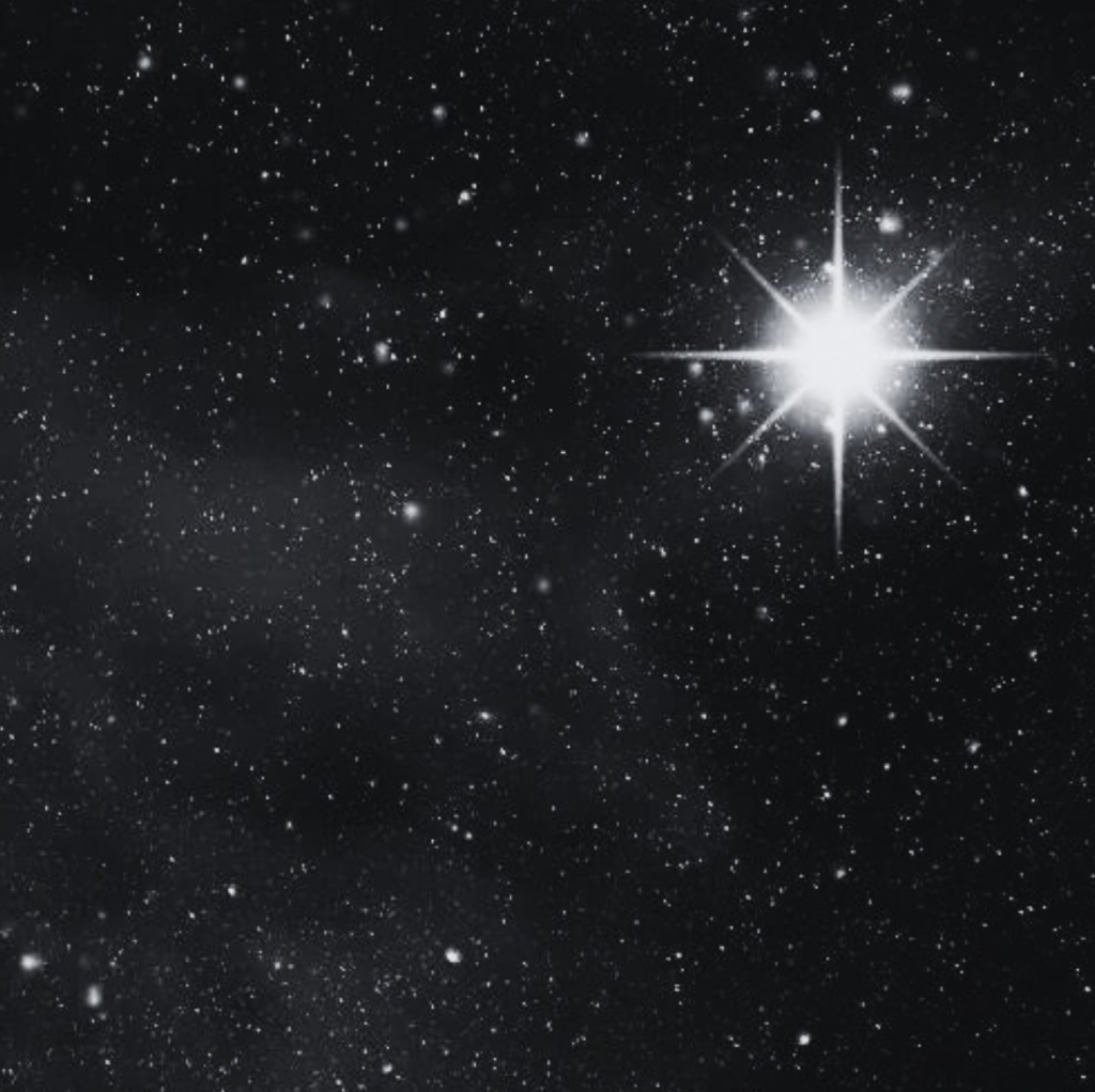 Bright star shining in a night sky filled with numerous smaller stars.